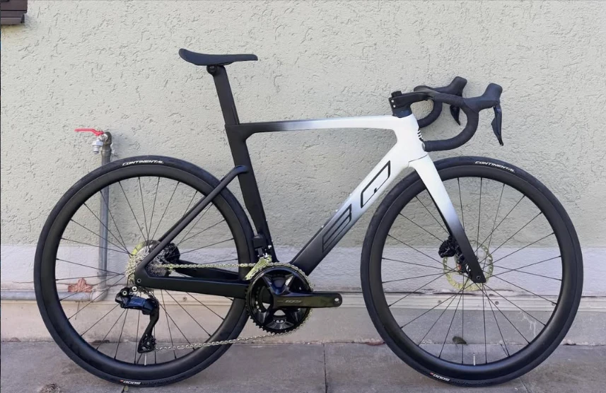 BQ Road Aero, Rennrad mit Farbverlauf von Weiß zu Schwarz, Seitenansicht vor einer Hauswand