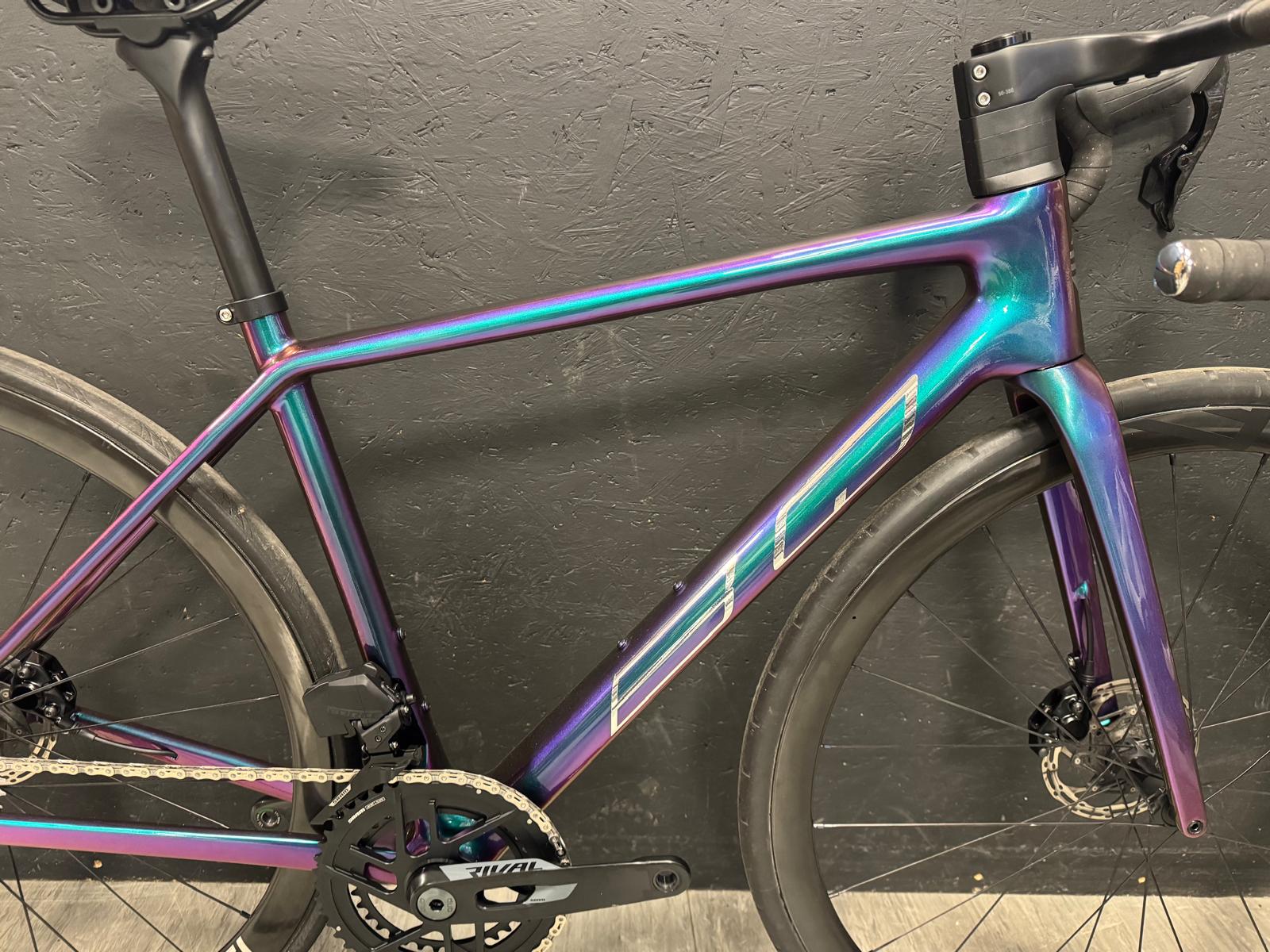 BQ Road Endurance mit schillernder Violett-Petrol-Lackierung vor einer schwarzen Wand, Seitenansicht