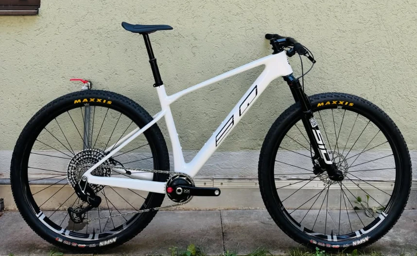 BQ Hardtail, weißer Carbon-Hardtail, Seitenansicht vor einer Hauswand