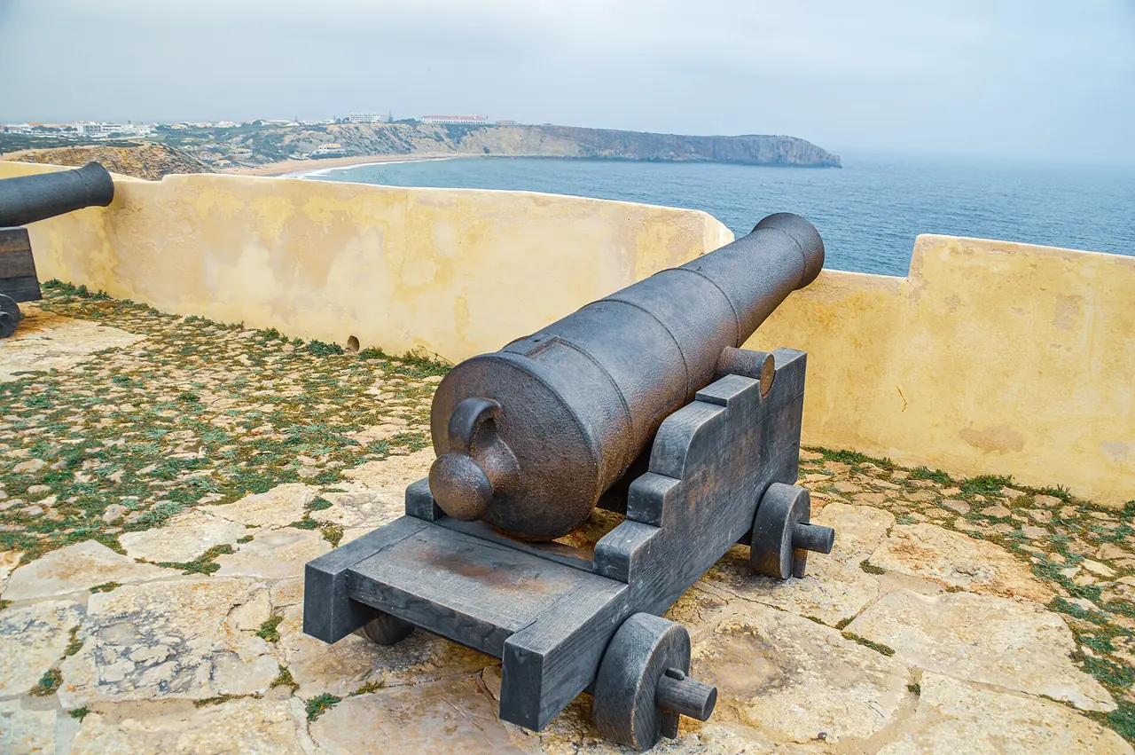 Eiserne Kanone auf der Mauer der Festung von Sagres, dahinter die Küste im Dunst